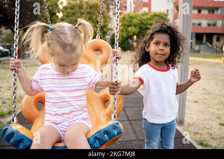 Deux enfants jouent ensemble sur l'aire de jeux Banque D'Images