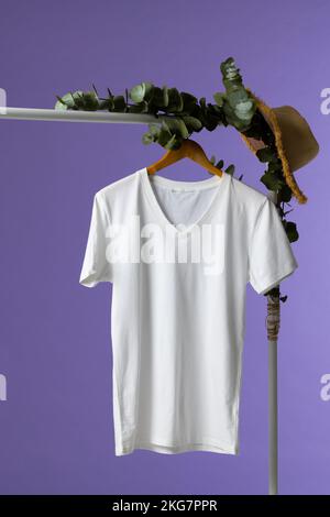 T-shirt suspendu sur un porte-manteau et espace pour copier sur fond violet Banque D'Images