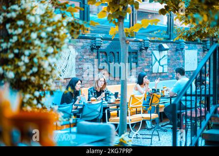 Les personnes qui mangent dans le jardin du restaurant Banque D'Images
