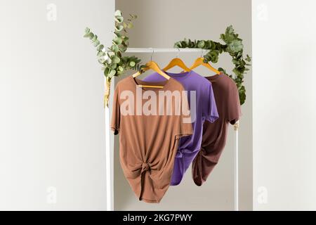 T-shirts affichés sur le rail de vêtements et espace de copie sur fond blanc Banque D'Images