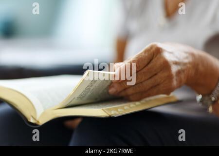 Gros plan des mains de la femme âgée sur la bible, plié dans la prière Banque D'Images