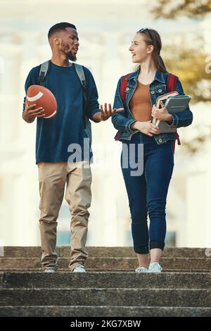 Étudiants, couple et conversation à pied sur les escaliers à l'université, université ou école livres. Amis, diversité et campus pour l'apprentissage, l'éducation ou Banque D'Images