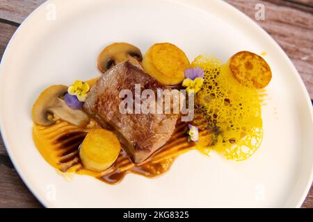 Recette de veau, confit de pomme de terre, champignons, purée de carottes, sauce au vinaigre balsamique, miel et veau Banque D'Images