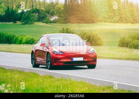 Berline Red Tesla modèle 3 voiture électrique année 2020 à grande vitesse sur autoroute. Ajout d'un filtrage dans la prod. Post. Salo, Finlande. 23 juin 2022. Banque D'Images