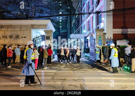 SHANGHAI, CHINE - le 22 NOVEMBRE 2022 - deux policiers scolaires gardent l'ordre des deux côtés du trottoir lorsque les élèves sortent d'une école secondaire en S. Banque D'Images