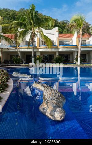 Une sculpture de crocodile au bord de la piscine dans un hôtel de villégiature sur la plage de Chahue dans les Bahias de Huatulco sur la côte Pacifique d'Oaxaca, au Mexique. Banque D'Images