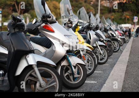 beaucoup de scooters et de motos sont garés dans une longue rangée Banque D'Images