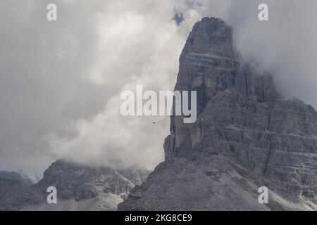 Hélicoptère utilisé pour les opérations de sauvetage sur le Tre Cime di Lavaredo dans les Dolomites, en Italie, par temps nuageux Banque D'Images