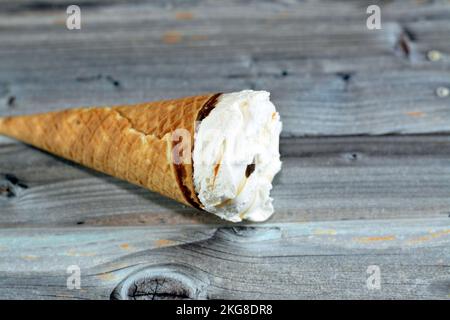 Cône de vanille à la crème glacée avec garniture de morceaux de copeaux de chocolat dans des cônes de cachets croustillants, foyer sélectif de la fusion de la crème glacée froide dans un bisc de cachets Banque D'Images