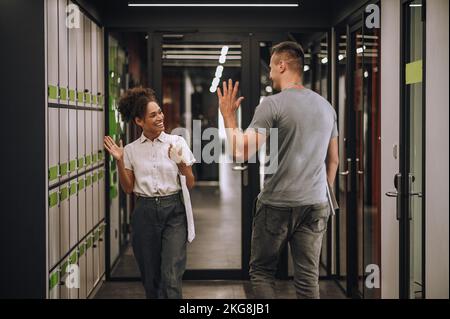 Une employée de bureau joyeuse vous saluant avec son collègue Banque D'Images