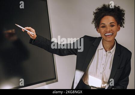 Jeune femme boss très animée donnant une présentation Banque D'Images