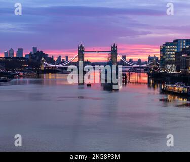 Un lever de soleil doré au-dessus de la Tamise avec pont de la tour et HMS Belfast, exposition longue. Banque D'Images