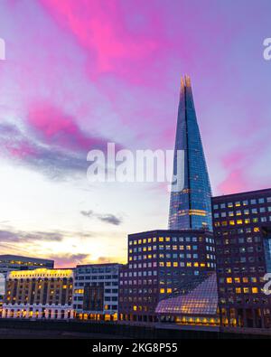 Une photo du Shard prise du pont de Londres avec des nuages magenta au lever du soleil. Banque D'Images