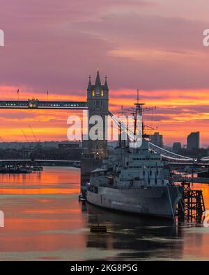 Un lever de soleil doré au-dessus de la Tamise avec pont de la tour et HMS Belfast, exposition longue. Banque D'Images