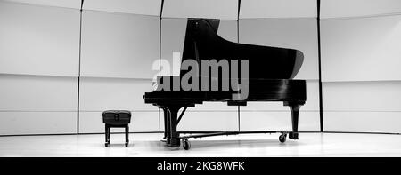 Piano noir et blanc avec banc d'essai sur l'état de concert pour la musique de performance théâtre musical Banque D'Images