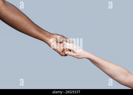 Femme et femme africaine main. Aide à la main, sauvetage, personnes multiathniques. Mains d'aide, geste de secours. Mains humaines noires et blanches. Afrique et Banque D'Images