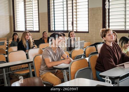 Étudiants de l'université en classe assistant à l'enseignant pendant qu'elle explique la leçon Banque D'Images