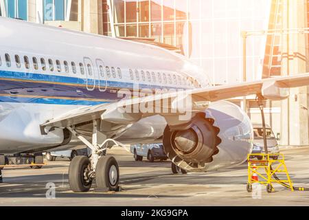 L'avion passager est stationné devant le terminal pour l'entretien avant le vol et le ravitaillement en carburant. Banque D'Images