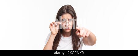 Gros plan portrait d'une femme suspecte, judgmentale dans des lunettes, blâmer quelqu'un, frognant, se calant sur la personne qu'elle blâme, pointant des accusations de doigt Banque D'Images