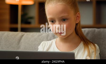 Enfant fille petit enfant tout-petit école primaire étudier avec l'ordinateur jouer jeux vidéo en ligne dans le cyberespace blond caucasien adolescent chat message Banque D'Images