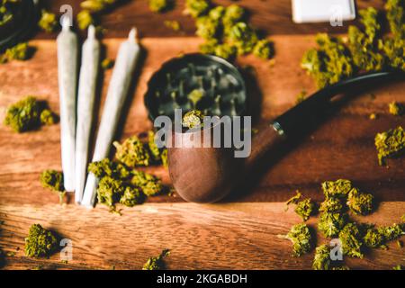 Tuyau en bois pour fumer sur la table contre le fond d'un bourgeon de cbd sativa ou indica tgk. Joints Banque D'Images