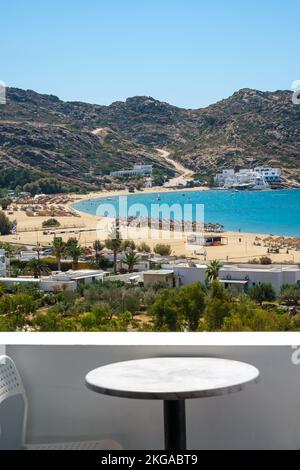 Vue incroyable depuis un balcon avec une chaise et une table donnant sur la célèbre plage Mylopotas à iOS Grèce Banque D'Images