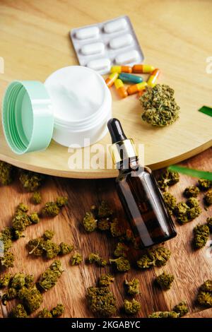 Marijuana cbd et thc. Les bourgeons de marijuana sont sur la table. Flacon en verre pour huile, cosmétiques avec pipette. Crème et cosmétiques avec de la marijuana, des pilules, medic Banque D'Images