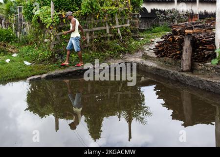 Réflexion d'un homme dans l'eau de la rivière. Il marche à travers le sommet. Ville d'Aratuipe, Bahia, Brésil. Banque D'Images