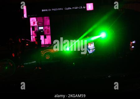 Naplouse, Palestine, 22/11/2022, Un faisceau laser est vu que les manifestants brûlent des pneus et ferment la route menant à la tombe de Joseph dans la ville de Naplouse, en Cisjordanie occupée. Les manifestants ont fait un geste audacieux pour empêcher les colons israéliens de se rendre au tombeau de Joseph après avoir organisé des manifestations, attaqué des propriétés palestiniennes et fermé les rues entourant la ville de Naplouse. Ce tombeau a longtemps été au centre du conflit entre juifs, chrétiens et musulmans. Certains juifs croient que Joseph biblique est enterré dans la tombe; les musulmans croient que Sheikh, un dirigeant arabe, est enterré à l'intérieur. Le Banque D'Images