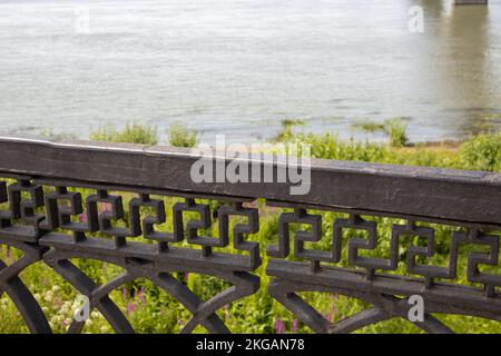 Conception technique de rails en fonte noire de la clôture de remblai, près du fond de la rivière et de l'herbe sur le Banque D'Images