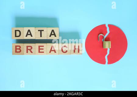 Concept de violation de données et de vol d'informations. Composition créative avec mot sur blocs de bois et cadenas ouvert. Banque D'Images