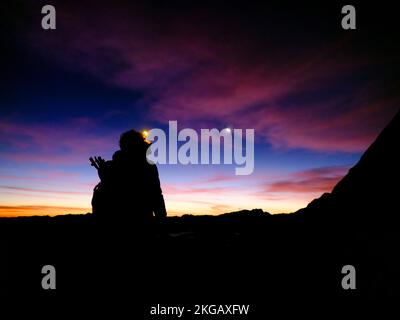 Silhouette d'une femme alpiniste avec phare à l'aube, Hoher Göll, Alpes de Berchtesgaden, Parc national de Berchtesgaden, Schönau am Königssee, Berchtesg Banque D'Images