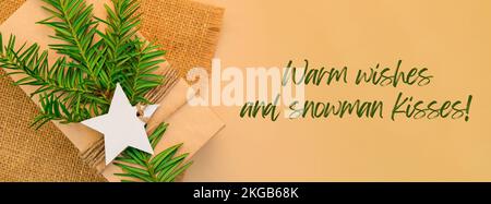 Voeux chaleureux et bonhomme de neige inspiration baiser citation phrase Box avec les cadeaux du nouvel an, enveloppé dans du papier artisanal et décoré avec une branche de sapin. Concept de vacances et de cadeaux. Un Noël vert alternative fait main et écologique présente une bannière zéro déchet Banque D'Images