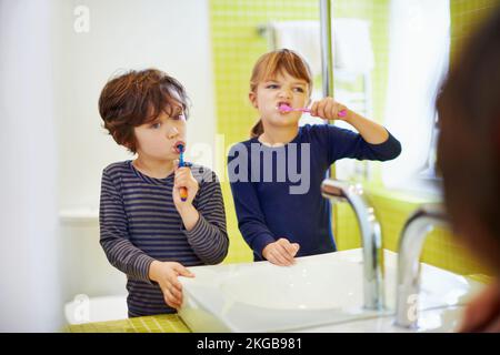 Leur mère leur a bien enseigné. un frère et une sœur se brossant les dents à la maison. Banque D'Images