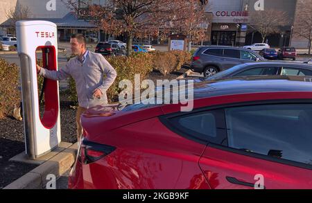 Colonie, États-Unis. 22nd novembre 2022. Un homme charge un Tesla modèle 3 à une station de charge de Colonie. Telsa a annoncé deux rappels en raison de problèmes de sac gonflable et de feu arrière touchant un total combiné de près de 352 000 véhicules X, 3 et Y. Crédit : SOPA Images Limited/Alamy Live News Banque D'Images