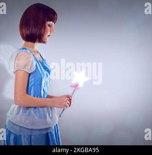 Ne cessez jamais de croire à la magie. Une courte photo d'une marraine de fée dans une robe bleue. Banque D'Images