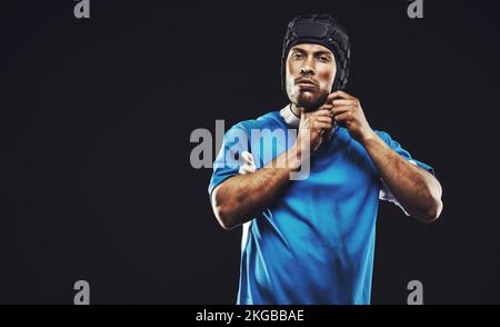 Rugby est sa chose. Photo d'un jeune joueur de rugby isolé sur fond noir. Banque D'Images