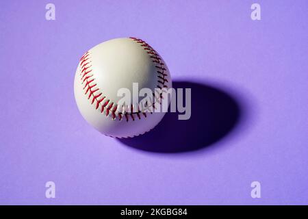 balle de baseball sur fond violet gros plan avec ombre Banque D'Images