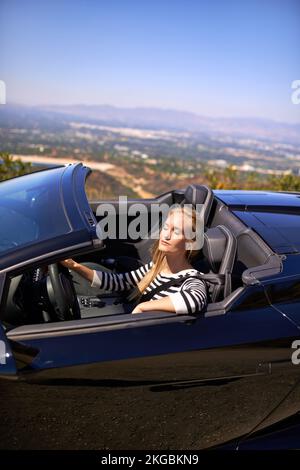 Une liberté totale sur la route. une jeune femme qui conduit dans une voiture de sport. Banque D'Images