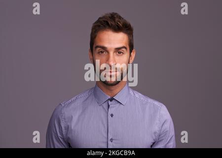 Robuste et maniement. Photo en studio d'un beau homme sur fond gris. Banque D'Images