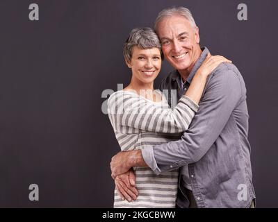 Leur amour est aussi fort que jamais. Portrait studio d'un couple affectueux et âgé sur fond gris. Banque D'Images