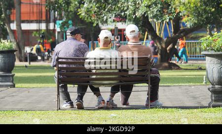 Amitié avec la vieillesse. Trois adultes s'assoient dans des chaises dans la ville d'Alun-alun Malang, à l'est de Java. MALANG, INDONÉSIE. 08 MARS 2018. Banque D'Images