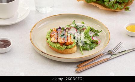 Portion de pain grillé à l'avocat avec crevettes et salade Banque D'Images