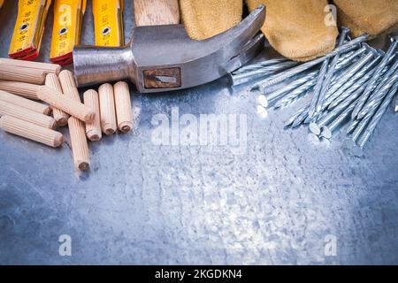 Marteau à griffe cuir gants de sécurité en bois construction compteur clous et chevilles sur fond métallique rayé concept d'entretien. Banque D'Images