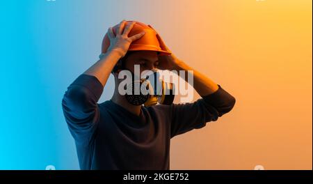 un homme dans un masque avec un filtre et un fond de couleur de casque Banque D'Images