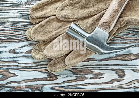 Gants de sécurité en cuir marteau à griffe sur panneau en bois. Banque D'Images