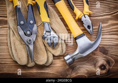 Gants de sécurité en cuir pince pour marteau à griffes clé réglable en acier sur panneau en bois. Banque D'Images