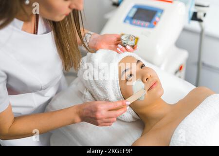 Charmante femme asiatique ayant des procédures faciales à la clinique de beauté, de taille moyenne. Photo de haute qualité Banque D'Images