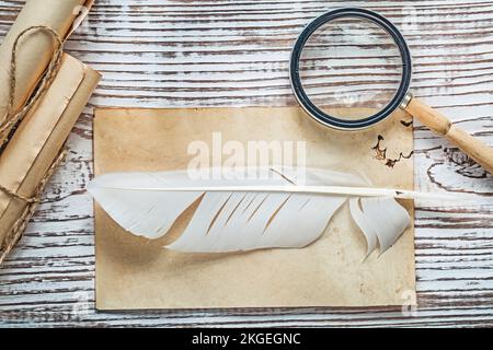 Ancienne feuille de papier filaire rouleau plume loupe sur panneau en bois vintage. Banque D'Images