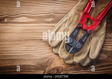 Gants de protection coupe-boulons sur bois concept de construction. Banque D'Images